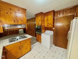 A kitchen with wood cabinets and appliances.