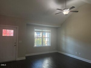A room with a ceiling fan and a door.