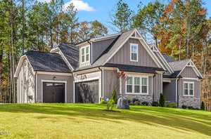 A house with a lawn and trees in the background.