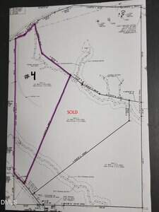 A black-and-white survey map showing multiple land parcels, one outlined in purple and labeled "#4." Another parcel in the center is labeled "SOLD" in red text. Contour lines and lot descriptions are visible throughout.