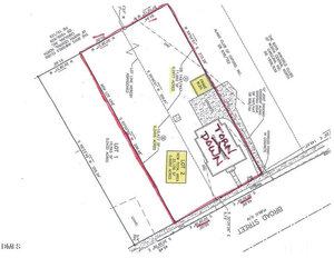 A property site plan outlined in red showing lot boundaries, existing structures, labeled areas, and measurements, with a note reading "Tear Down" over the house along Broad Street.