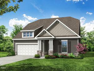 A modern single-family house with gray siding, brown roof shingles, white trim, and a two-car garage. The front yard features green grass, shrubs, and small red flowers. Trees and a blue sky with clouds are in the background.