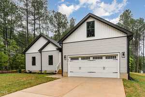 A house with a driveway and trees.