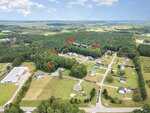 Aerial view of a rural Louisburg neighborhood with scattered houses, trees, and open fields. Red arrows point to multiple homes along Ridge Haven Dr., including 65 Ridge Haven Drive. Street names Cotton Dr., Hartley Ct., and Twin Creek Dr. are labeled.