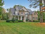 A two-story suburban house at 35 Siltstone Drive in Franklinton features gray siding, stone accents, white trim, and a covered front porch, all set on a well-maintained lawn bordered by shrubs and trees under a blue sky.