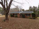 A brick house on 994 Alert Road with a tree in the back, nestled in charming Warrenton.