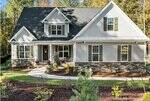 A two-story suburban house at 40 Yellowstone Court, Youngsville, with gray siding, a dark shingled roof, stone accents, white trim, and green shutters. The front yard features a curved sidewalk, landscaping, and potted porch plants.