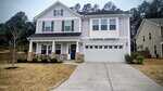 A two-story suburban house at 80 Wolverton Way in Franklinton with white siding, black shutters, a columned front porch, and a double garage. The yard features sparse yellow grass and a concrete driveway, with trees and neighbors nearby.