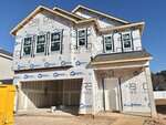 A two-story house under construction at 24 Gerrad Street, Franklinton, is covered in white weather-resistant sheeting with exposed wood framing. Windows are installed, and the garage and front door are visible. A yellow dumpster sits to the left.