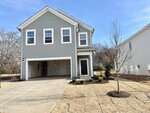 Located in Franklinton, 20 Gerrad Street is a two-story gray house with white trim and a double garage. The front yard features new sod, a small tree, and minimal landscaping, all under a clear blue sky.