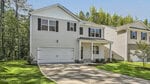 Located at 90 Babbling Creek Drive in Youngsville, this modern two-story house features light-colored siding, dark shutters, and a double garage. A covered front porch and well-maintained lawn are surrounded by tall trees and neighboring homes.