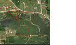 Aerial map highlights land parcels near Upchurch Road in Zebulon: one labeled 2.43 acres and another 15.50 acres. Roads, fields, wooded areas, and buildings marked with red dots are also visible.