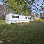 A white mobile home sits in a yard on 979 Alert Road, just outside Louisburg.