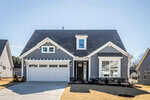 A modern, gray two-story house with white trim at 90 Slippery Elm Road in Youngsville features a front porch, large windows, a double garage, and a neatly manicured lawn under a clear blue sky.
