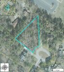 Aerial map of Lot 5 Sidney Hill in Henderson: a wooded, triangular lot outlined in blue at the end of a cul-de-sac, surrounded by houses and trees, with a parking lot and street grid inset at the top left corner.