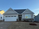 Charming single-story, light gray house with white trim at 60 Slippery Elm Road, Youngsville. Features a double garage, gable roof, fresh landscaping, and a "For Sale" sign in the front window under a clear, sunny sky.