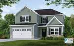A two-story house with light green siding, white trim, black shutters, and a dark gray roof. It has a double garage, front porch, manicured lawn, and some shrubs. A builder's logo is visible in the bottom right corner.