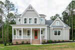 Two-story house with light gray siding, white trim, and a covered front porch with columns. There are several windows, brick steps leading to the front door, and minimal landscaping in the front yard. Trees are in the background.