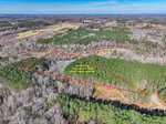 Aerial view of a wooded area with a red outline marking a section of land. Text inside the outline reads, "Not a survey. Line does not show legal property boundary." A road runs along the lower right edge.