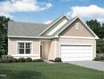 A single-story, beige house with white trim, a gray shingled roof, and an attached two-car garage. There are bushes along the front and a driveway leading to the garage. Blue sky with scattered clouds overhead.