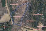 A map shows a wooded property outlined in blue labeled "8422 Charlie Stovall Rd," with nearby parcels labeled with addresses, yellow property lines, and roads running along the boundaries.