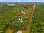 Aerial view of a forested area divided into two sections outlined in red, each labeled "10 acres" with numbers 1 and 2. Surrounding areas are also covered in dense trees, with a small clearing at the bottom.