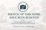 A notice with a camera icon and a line through it states, "Photos of this home have been removed. At the homeowner's request, photos of this property have been removed. Thank you for your understanding." A house is faintly visible in the background.