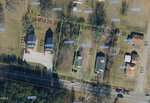 Aerial view of a residential neighborhood in Franklinton with lot boundaries and numbers overlaid, showing three houses on green-bordered lots along 709 E Green Street, surrounded by other numbered properties and trees.