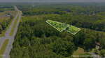 Aerial view of a wooded area beside a divided highway near 80 Cannady Way, Franklinton, with approximate property lines highlighted in white, indicating land boundaries within the dense forest.