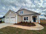 Single-story modern suburban house at 137 Sugarmaple Way in Youngsville, featuring beige siding, white trim, a two-car garage, covered porch, blue front door, and a newly landscaped front yard under a cloudy sky.