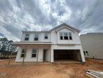 A newly constructed two-story white house at 5 Heartleaf Square, Youngsville, features a covered porch and open garage on a dirt lot under a cloudy sky. The home offers multiple windows and unfinished landscaping.