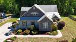 Aerial view of a two-story house at 3516 Bluebonnet Drive, Wake Forest, with gray siding and stone accents, landscaped shrubs and trees, a curved driveway, a fenced backyard, and lush green trees surrounding the property.