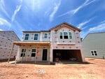 A two-story house under construction at 164 Sugarmaple Way in Youngsville features exposed framing, insulation, and window openings on a dirt lot beneath a blue sky. The neighboring house is partially visible on either side.