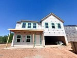 A two-story house at 168 Sugarmaple Way in Youngsville is under construction, covered in white insulation wrap with exposed wooden beams. The garage is open with supplies inside, and bare dirt surrounds the home beneath a clear blue sky.