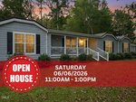 A single-story gray house with white trim and a front porch, surrounded by trees at dusk in Creedmoor. A red banner at 1635 US 15 announces an open house on Saturday, 06/06/2026, from 11:00 AM to 1:00 PM.