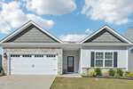 Charming single-story suburban house at 103 Blue Hydrangea Way, Youngsville, with two gabled roofs, stone and siding exterior, double garage doors, a red front door, small porch, manicured lawn, and a blue sky with scattered clouds.
