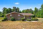 Charming single-story brick house in Oxford at 3662 W Antioch Drive, featuring a gable roof, arched windows, and a covered front porch, surrounded by shrubs and trees with a dry, patchy lawn in the foreground.