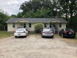 A single-story, light yellow house with a small front porch sits among trees at 752 David Street, Henderson. Three cars are parked in the gravel driveway out front, and the weather is cloudy.