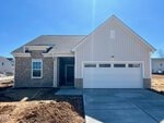 Single-story house at 212 Tar Banks Drive in Louisburg, featuring stone and beige siding, a covered porch, and a double garage on a newly constructed lot with unfinished landscaping on a clear, sunny day.