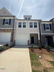 Two-story townhouse at 224 Alberta Drive in Franklinton with gray siding, white trim, a single-car garage, and a small front porch. The driveway and lawn are visible in the foreground, with landscaping and shrubbery near the entrance.