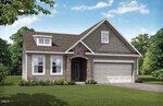 A modern single-story house at 190 Sawtooth Oak Lane in Youngsville, with beige siding, a stone-accented entryway, gable roof, dormer window, two-car garage, and a landscaped yard with green lawn and shrubs against trees and blue sky.