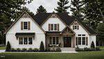 A modern farmhouse on Lot 1 Watkins Wilkinson Road in Oxford, featuring white board-and-batten siding, dark wooden shutters, a black roof, and a covered front porch with wooden beams, set among neatly trimmed bushes and tall trees.