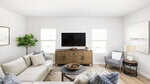 A modern, bright living room at 106 Airdale Drive in Oxford features a white sectional sofa, patterned pillows, a round coffee table, flat-screen TV on a wooden console, an armchair, potted plant, table lamp, and large wall art on white walls.