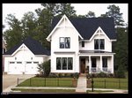 A modern white two-story house with black trim is located at 25 Bright Horizon Lane, Louisburg. Featuring a front porch, separate two-car garage, manicured lawn, brick pathway, and a black iron fence, this home is beautifully surrounded by tall trees in the background.