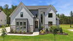 Modern two-story house at 35 Chestnut Oak Drive in Youngsville, featuring gray vertical siding, stone accents, large windows, and a front lawn with landscaped bushes and trees under a clear blue sky.