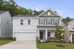 Two-story suburban house at 65 Carolina Maple Drive, Franklinton, with gray siding, white trim, a covered front porch, double garage, and landscaped front yard, set against a backdrop of trees under a blue sky.