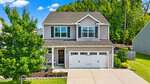 Two-story suburban house with gray siding, white trim, and two-car garage located at 190 Kimberling Drive in Franklinton. Well-maintained lawn and landscaping, large tree in the front yard, and a wooden fence in the backyard. Bright, sunny day with blue sky and green trees.