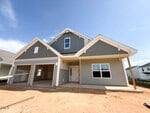A newly built gray and white house at 93 Moon Flower Walk in Youngsville features an attached two-car garage, covered entryway, large front window, and an unfinished yard under a clear blue sky.