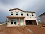 A two-story house under construction at 12 Silverbell Court in Youngsville, featuring exposed sheathing, several windows installed, and an unfinished front porch. The ground is bare dirt, with neighboring houses visible in the background.