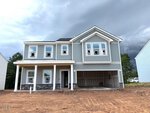 A two-story gray house with white trim, a covered front porch, and an attached two-car garage is shown on bare dirt at 41 Plantation Drive in Youngsville, with overcast skies and unfinished landscaping.